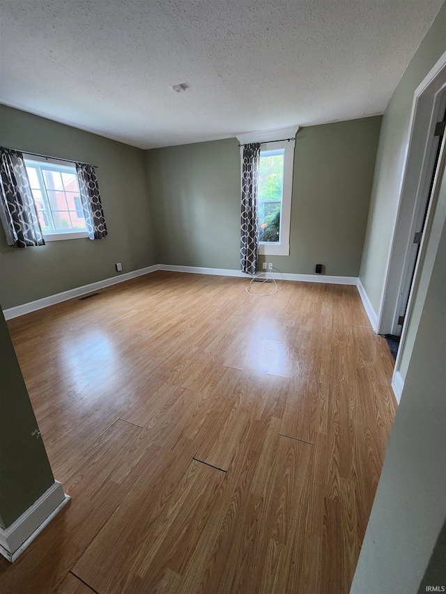 206 S Van Buren St, Monroe, IN 46772 - spare room with wood finished floors, healthy amount of natural light, a textured ceiling, and baseboards