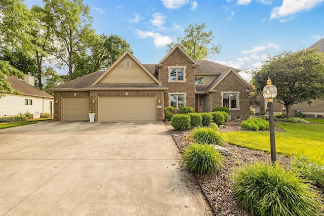 6615 Cherry Hill Pkwy, Fort Wayne, IN 46835 - view of front of house with brick siding, an attached garage, a front yard, and driveway