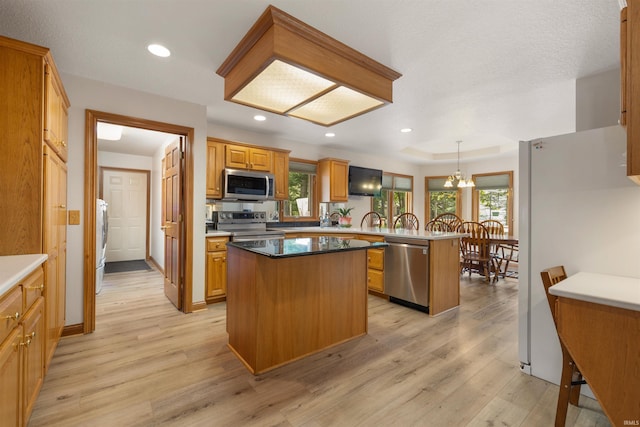 6615 Cherry Hill Pkwy, Fort Wayne, IN 46835 - kitchen with stainless steel appliances, light wood-style floors, a peninsula, a kitchen island, and plenty of natural light