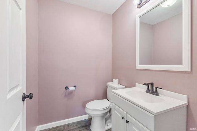 340 W Turner St, Bloomfield, IN 47424 - half bathroom with vanity, toilet, wood finished floors, and baseboards
