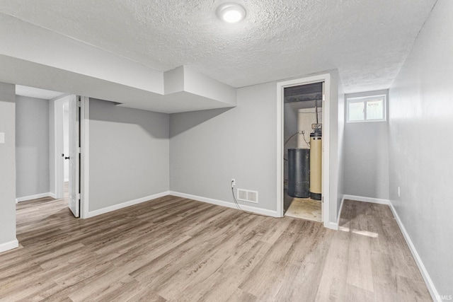 340 W Turner St, Bloomfield, IN 47424 - below grade area featuring wood finished floors, a textured ceiling, baseboards, and a water softener system