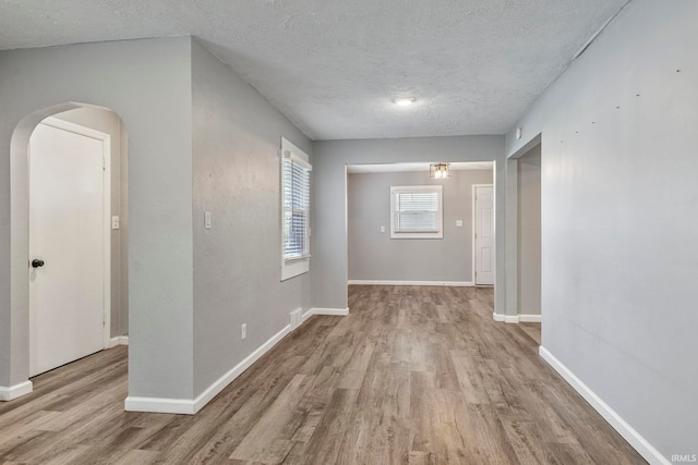 340 W Turner St, Bloomfield, IN 47424 - unfurnished room featuring wood finished floors, a textured ceiling, arched walkways, and baseboards