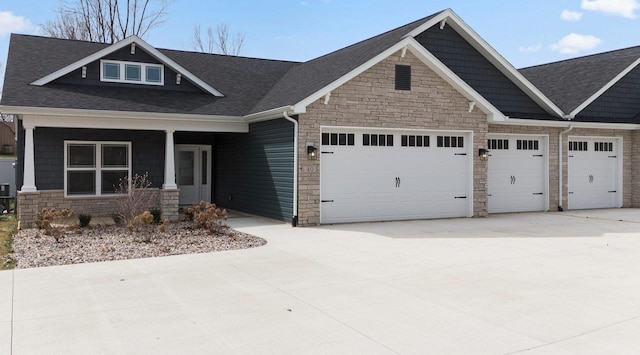 60 Ln 520 Lake James Unit 19, Fremont, IN 46737 - craftsman house featuring a garage, stone siding, concrete driveway, and roof with shingles