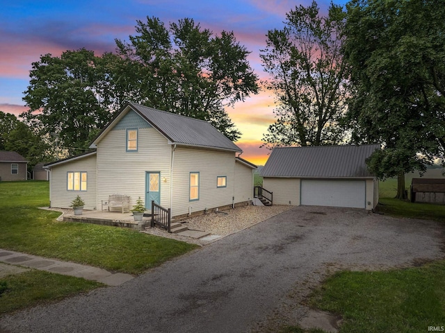 503 Graceland Ave, Claypool, IN 46510 - property exterior at dusk featuring an outbuilding, metal roof, a yard, and a detached garage