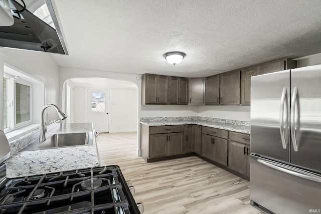 503 Graceland Ave, Claypool, IN 46510 - kitchen featuring stainless steel fridge, a sink, arched walkways, light wood-style floors, and a textured ceiling
