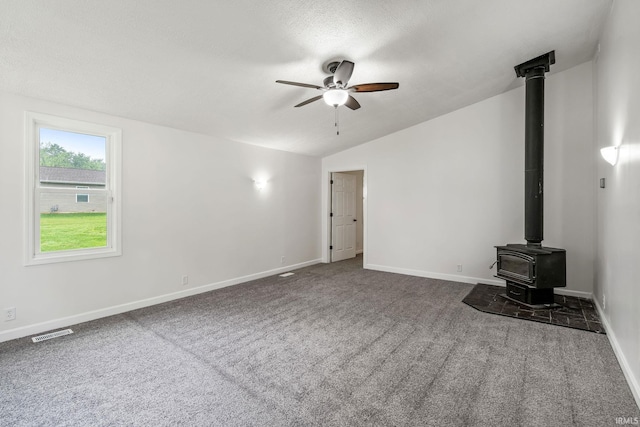 503 Graceland Ave, Claypool, IN 46510 - unfurnished living room with a wood stove, ceiling fan, lofted ceiling, baseboards, and dark colored carpet