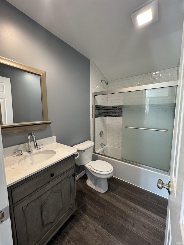 1509 N Leeds St, Kokomo, IN 46902 - bathroom with toilet, vaulted ceiling, vanity, wood finished floors, and bath / shower combo with glass door