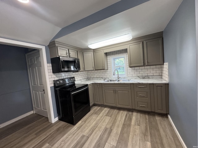1509 N Leeds St, Kokomo, IN 46902 - kitchen with stainless steel microwave, black range with electric stovetop, a sink, gray cabinetry, and light wood finished floors