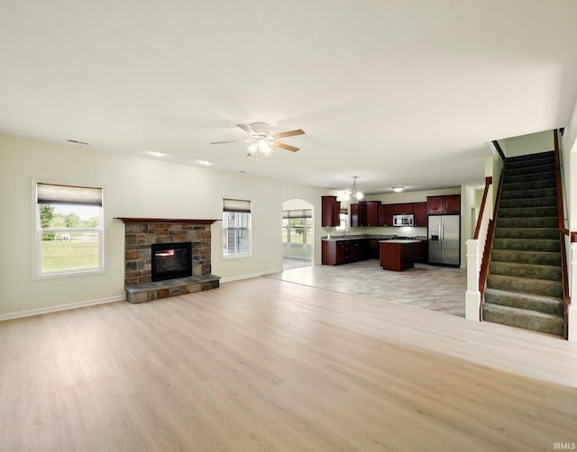 13395 Synch Ct, Fort Wayne, IN 46814 - unfurnished living room featuring light wood finished floors, a chandelier, ceiling fan, stairway, and baseboards