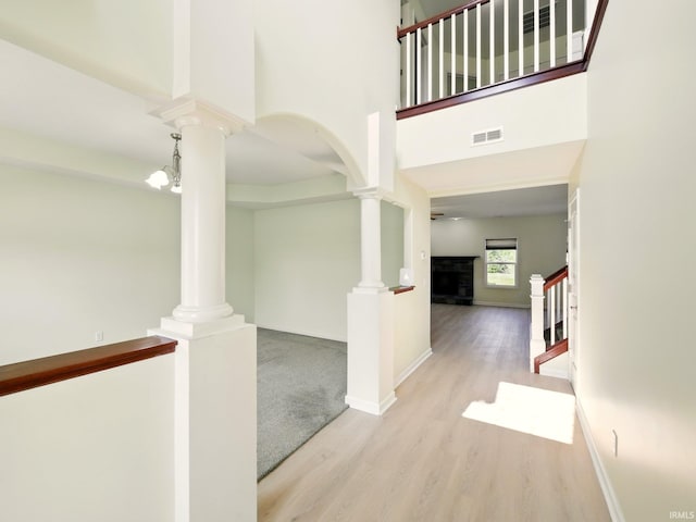 13395 Synch Ct, Fort Wayne, IN 46814 - hall featuring decorative columns, wood finished floors, stairs, baseboards, and a towering ceiling