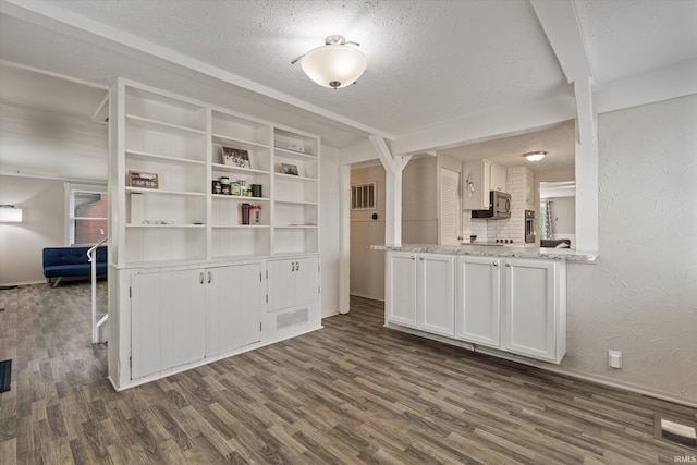 2527 Woodmont Dr, South Bend, IN 46614 - kitchen featuring dark wood-style flooring, white cabinetry, a textured ceiling, a textured wall, and light stone countertops