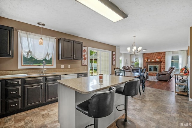 230 Meadows Dr, Greentown, IN 46936 - kitchen featuring a sink, a chandelier, pendant lighting, a kitchen breakfast bar, and a textured ceiling