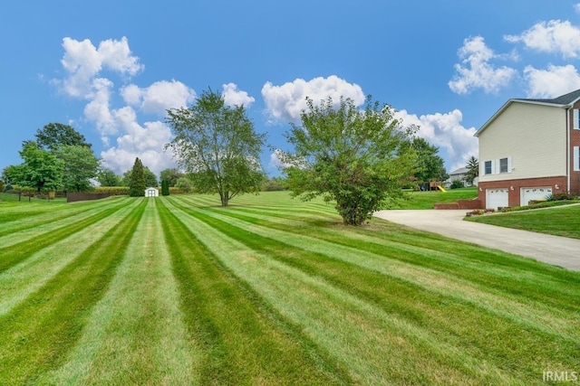 230 Meadows Dr, Greentown, IN 46936 - view of grassy yard featuring an attached garage and driveway
