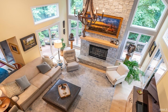 5920 E Lampkins Ridge Rd, Bloomington, IN 47401 - living area with a high ceiling, a fireplace, a chandelier, and wood finished floors
