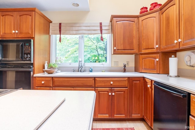 5920 E Lampkins Ridge Rd, Bloomington, IN 47401 - kitchen featuring black appliances, a sink, light countertops, and brown cabinetry