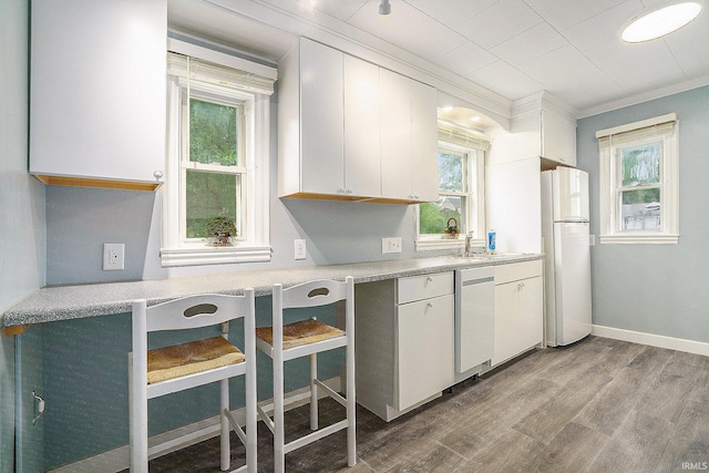 1826 E Donald St, South Bend, IN 46613 - kitchen with freestanding refrigerator, dishwashing machine, wood finished floors, crown molding, and white cabinets