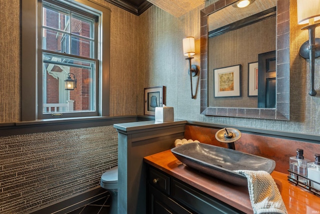 1403 E Jefferson Blvd, South Bend, IN 46617 - bathroom featuring toilet, ornamental molding, vanity, and wallpapered walls