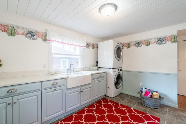 620 Ln 330 Big Otter Lk, Fremont, IN 46737 - laundry area featuring stacked washer / dryer, a wainscoted wall, cabinet space, and wallpapered walls