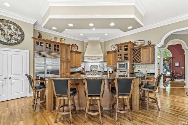 1411 Santanna Dr, Lafayette, IN 47905 - kitchen with brown cabinets, built in appliances, custom exhaust hood, ornate columns, and recessed lighting