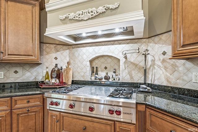1411 Santanna Dr, Lafayette, IN 47905 - kitchen with stainless steel gas stovetop, custom exhaust hood, brown cabinetry, and tasteful backsplash