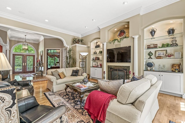 1411 Santanna Dr, Lafayette, IN 47905 - living area featuring decorative columns, built in shelves, a fireplace, light wood finished floors, and french doors