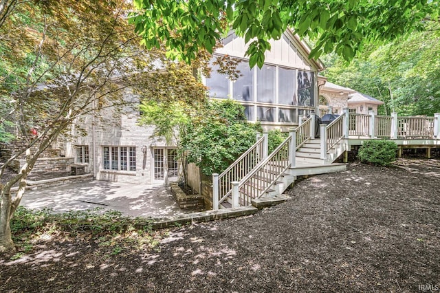 1411 Santanna Dr, Lafayette, IN 47905 - back of house featuring stairway, a wooden deck, a patio area, a sunroom, and brick siding