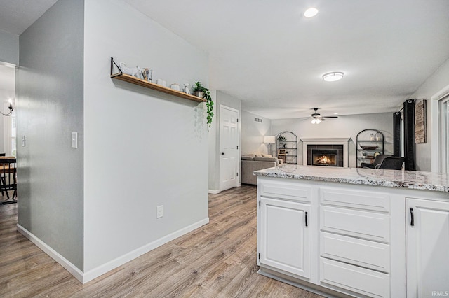 55177 Ardith St, Osceola, IN 46561 - kitchen with a ceiling fan, light wood-style floors, white cabinets, light stone counters, and recessed lighting