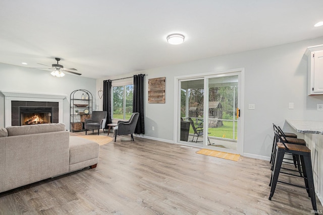 55177 Ardith St, Osceola, IN 46561 - living room with ceiling fan, light wood-style flooring, a tile fireplace, baseboards, and recessed lighting