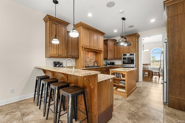 4906 N 100 W, Uniondale, IN 46791 - kitchen with appliances with stainless steel finishes, a peninsula, brown cabinets, light stone counters, and recessed lighting