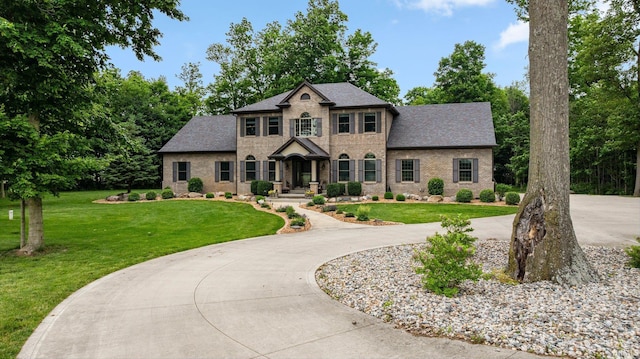 4906 N 100 W, Uniondale, IN 46791 - view of front of house featuring brick siding, a front lawn, a shingled roof, and curved driveway