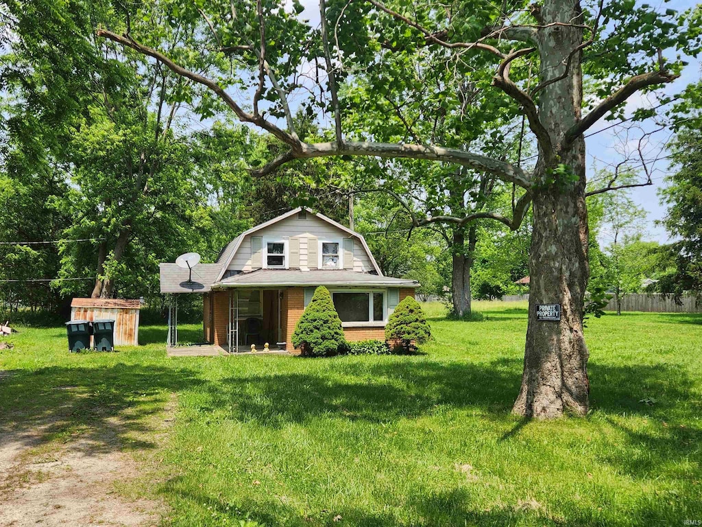 2624 E Memorial Dr, Muncie, IN 47302 - view of front facade featuring a gambrel roof, a front yard, and brick siding