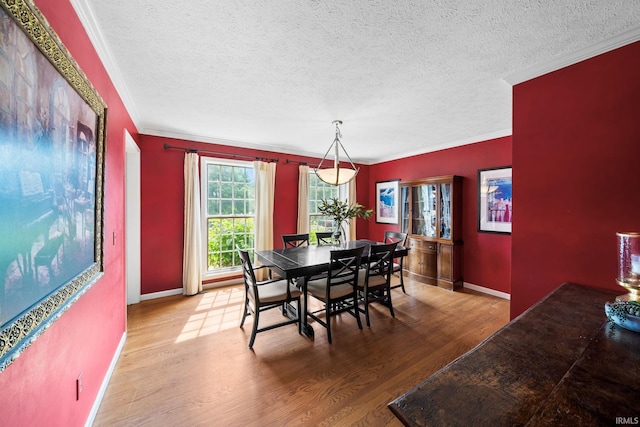 51803 Foxdale Ln, Granger, IN 46530 - dining room with crown molding, wood finished floors, a textured ceiling, and baseboards
