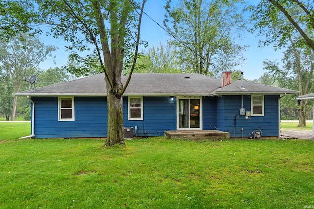 9014 Muldoon Rd, Fort Wayne, IN 46819 - back of house with a chimney, a lawn, and central AC