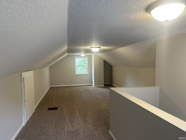 3324 Alexander St, Fort Wayne, IN 46806 - additional living space with a textured ceiling, dark colored carpet, baseboards, and vaulted ceiling