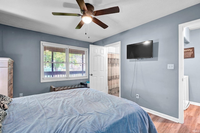 9617 S Lake Ridge Dr Unit 4, Bloomington, IN 47401 - bedroom featuring light wood finished floors, baseboards, ceiling fan, and ensuite bath