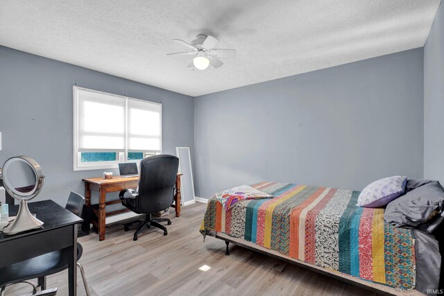 9617 S Lake Ridge Dr Unit 4, Bloomington, IN 47401 - bedroom with light wood finished floors, a textured ceiling, a desk, ceiling fan, and baseboards
