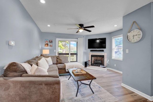 9617 S Lake Ridge Dr Unit 4, Bloomington, IN 47401 - living area with light wood-style floors, ceiling fan, a fireplace with raised hearth, recessed lighting, and baseboards