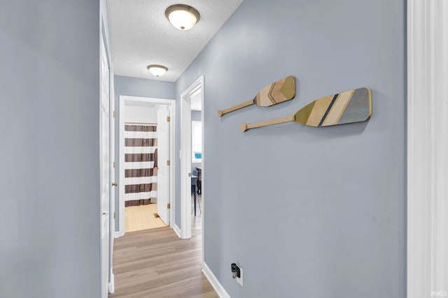 9617 S Lake Ridge Dr Unit 4, Bloomington, IN 47401 - hall with a textured ceiling, light wood finished floors, and baseboards