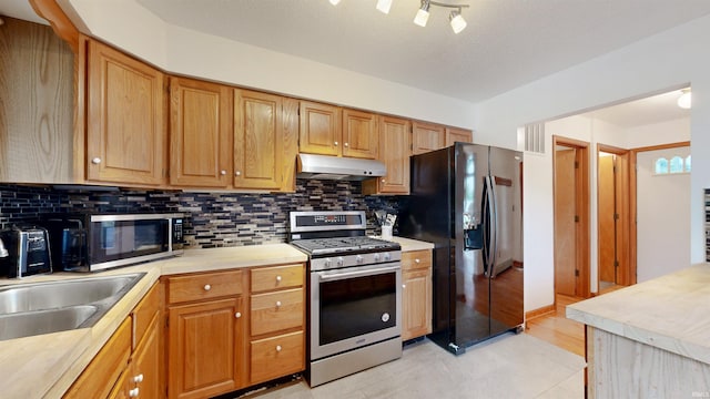 7333 W Newton Stewart Rd, Taswell, IN 47175 - kitchen featuring stainless steel appliances, under cabinet range hood, light countertops, decorative backsplash, and a sink