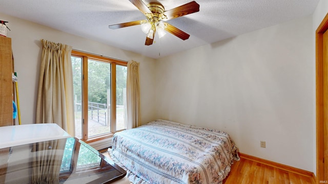 7333 W Newton Stewart Rd, Taswell, IN 47175 - bedroom featuring light wood-style flooring, a textured ceiling, baseboards, and ceiling fan