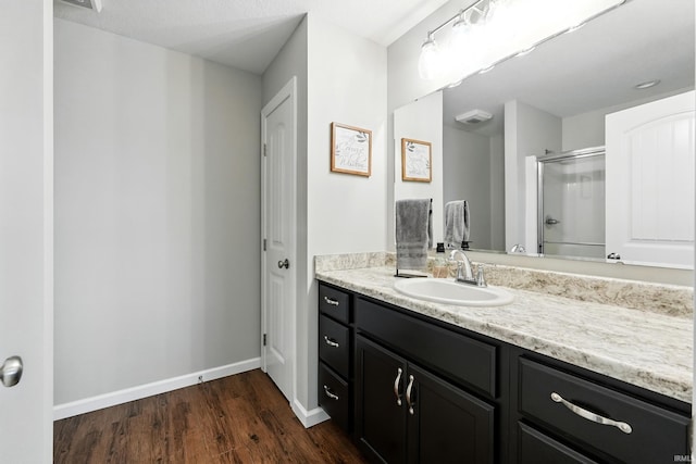 1308 Hideaway Dr, Auburn, IN 46706 - bathroom with vanity, a shower stall, wood finished floors, and baseboards