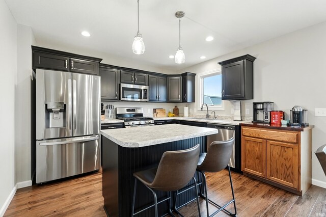 1308 Hideaway Dr, Auburn, IN 46706 - kitchen featuring appliances with stainless steel finishes, a sink, a kitchen island, wood finished floors, and recessed lighting