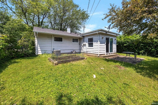 1330 Helmen Dr, South Bend, IN 46615 - rear view of property featuring a garden, a yard, a chimney, and central AC unit