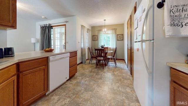 12 Vicki Dr, Vincennes, IN 47591 - kitchen with white appliances, brown cabinets, light countertops, a textured ceiling, and pendant lighting