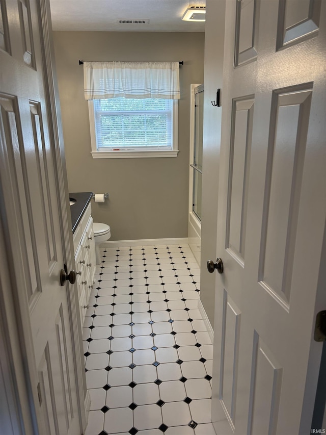 39 Hannah Ln, Jasper, IN 47546 - bathroom featuring vanity, toilet, tile patterned floors, baseboards, and bath / shower combo with glass door