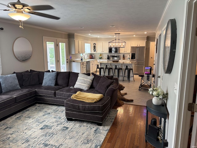 39 Hannah Ln, Jasper, IN 47546 - living room featuring crown molding, a ceiling fan, a chandelier, and light wood-style floors