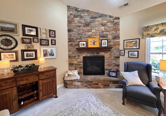 4691 Flagship Ln, Lafayette, IN 47909 - living area featuring carpet, vaulted ceiling, a textured ceiling, and a stone fireplace
