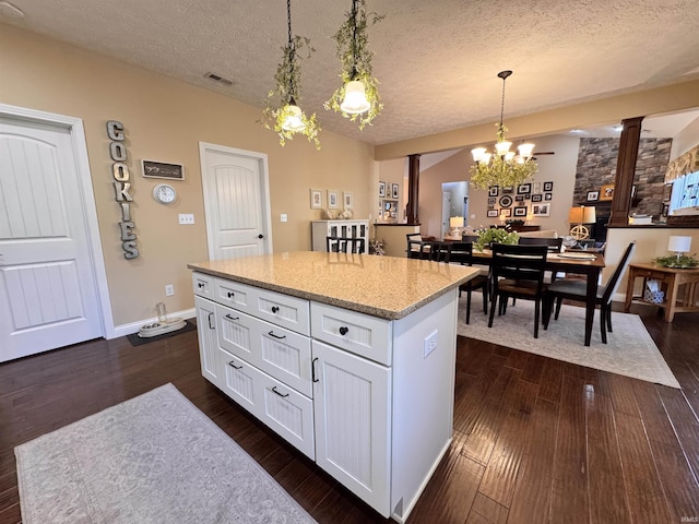 4691 Flagship Ln, Lafayette, IN 47909 - kitchen featuring a textured ceiling, a chandelier, a center island, decorative light fixtures, and white cabinets