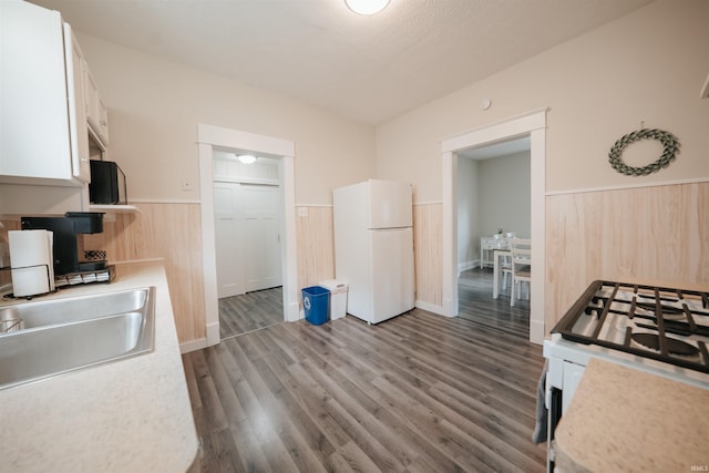 1014 W 7th St, Mishawaka, IN 46544 - kitchen featuring white appliances, wainscoting, light countertops, a sink, and white cabinets