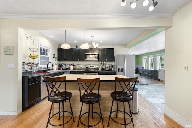 2890 W 400 N, Columbia City, IN 46725 - kitchen featuring stainless steel appliances, dark cabinets, a kitchen bar, a chandelier, and backsplash